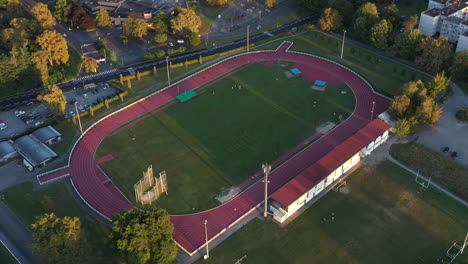 Luftaufnahme-Der-Leichtathletik-Laufbahnen-Und-Des-Sonnenuntergangs-Auf-Dem-Sportplatz-Mit-Grünem-Gras
